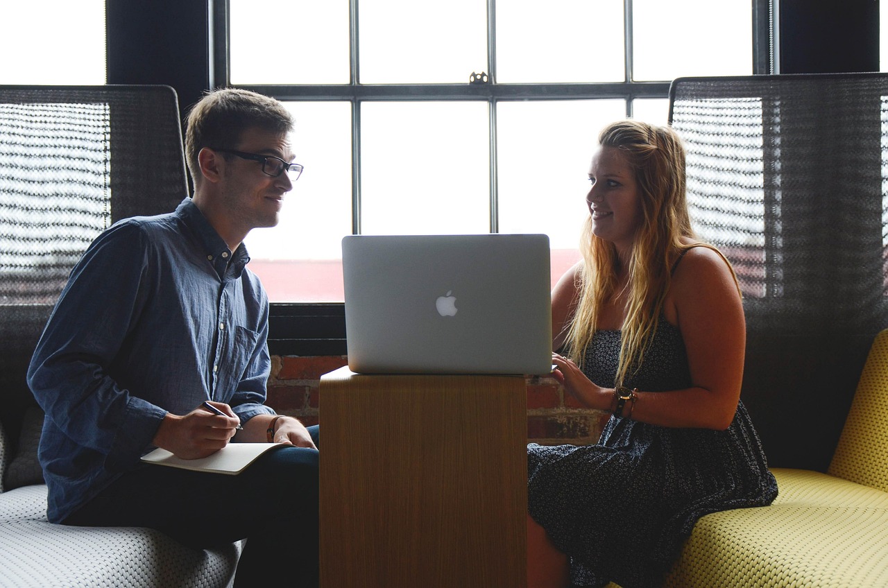 Two people reviewing figures together on a laptop