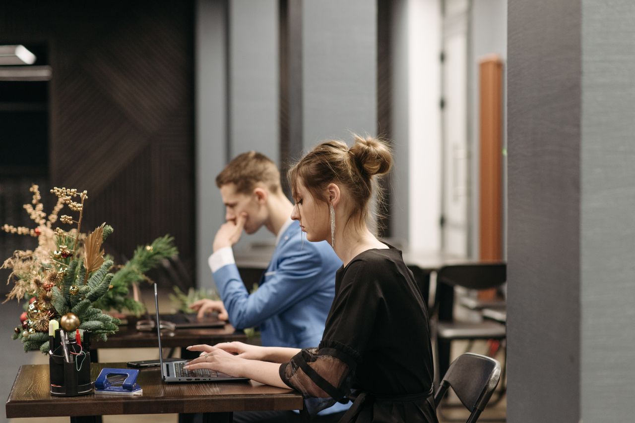 Collega's aan het werk aan gedeelde bureaus in een licht kantoor