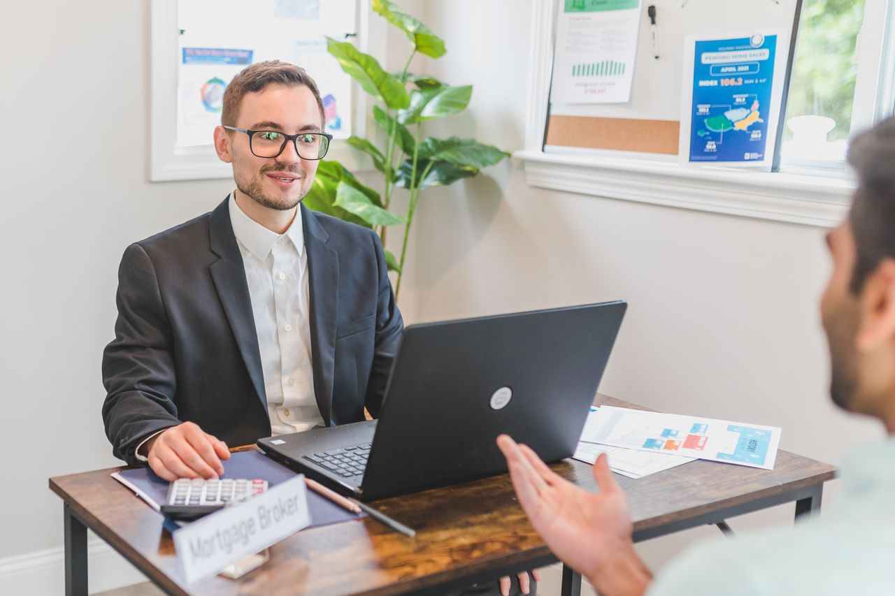 Adviseur in gesprek met een klant aan zijn bureau